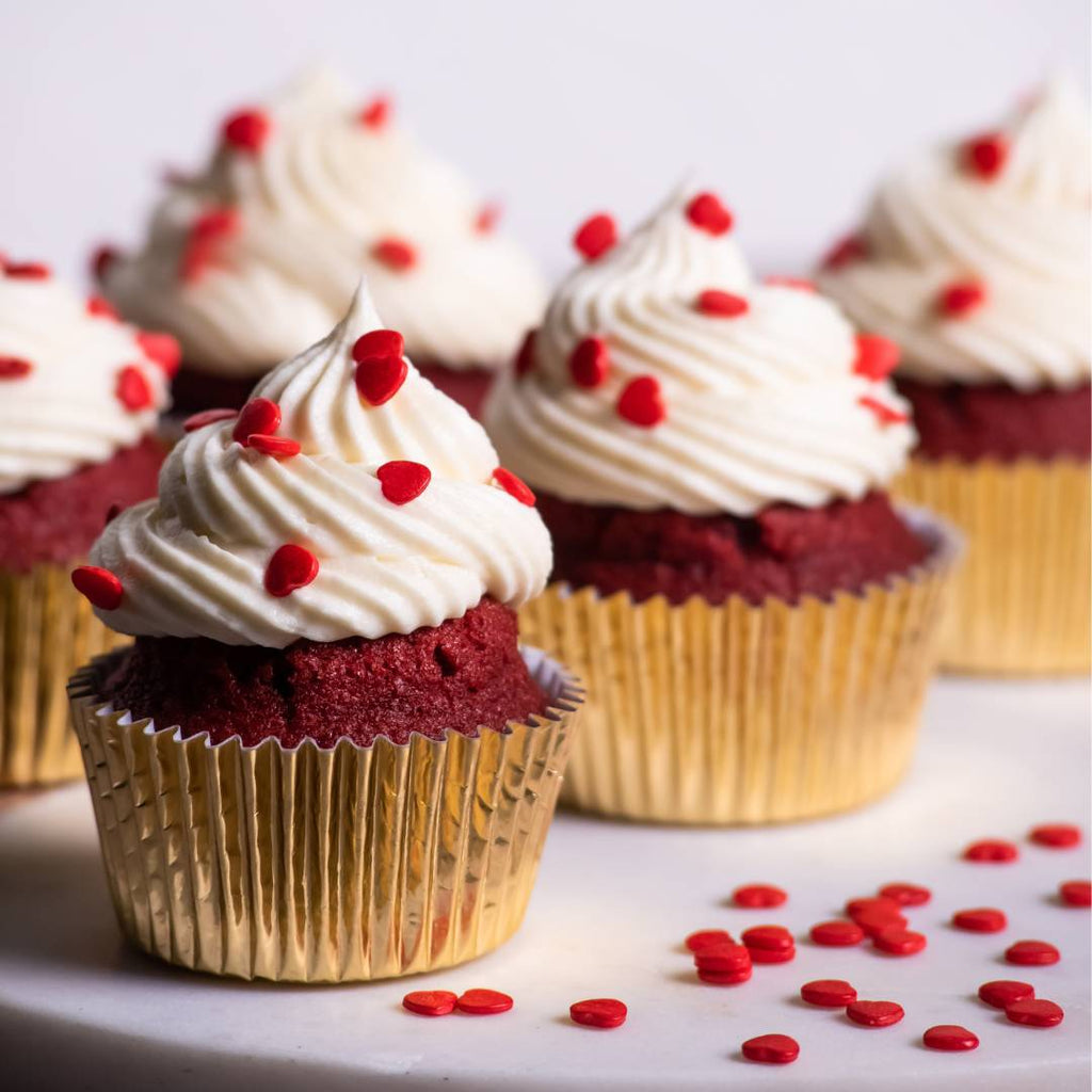 Cupcakes red velvet con frosting de queso crema y sprinkles