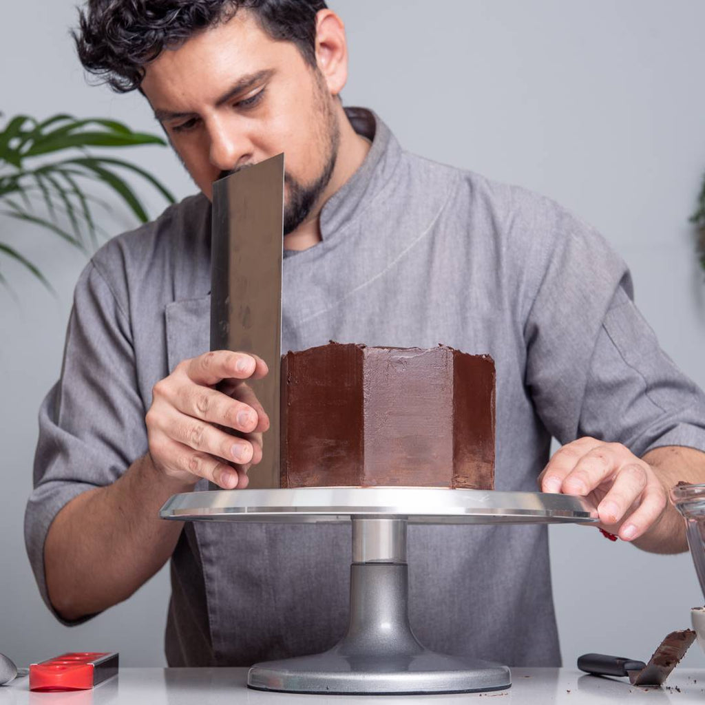 Chef Leonardo sellando un pastel con ganache de chocolate semiamargo